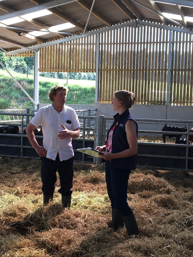 Dairy farmer and AHDB consultant chatting in straw barn